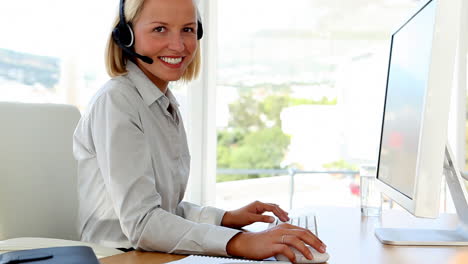 businesswoman talking on headset and typing