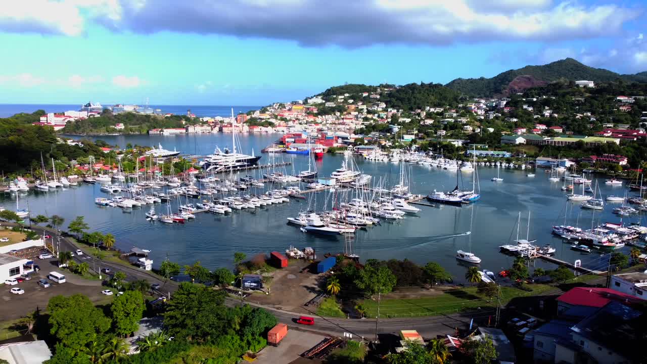 Aerial descent on harbour with yachts and small boat arriving