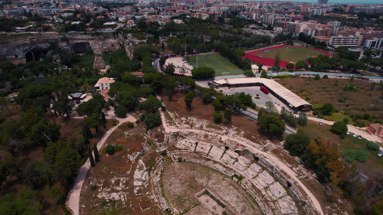 Archaeological structures and historic Roman Greek theater ruins in Siracusa. Aerial drone footage.