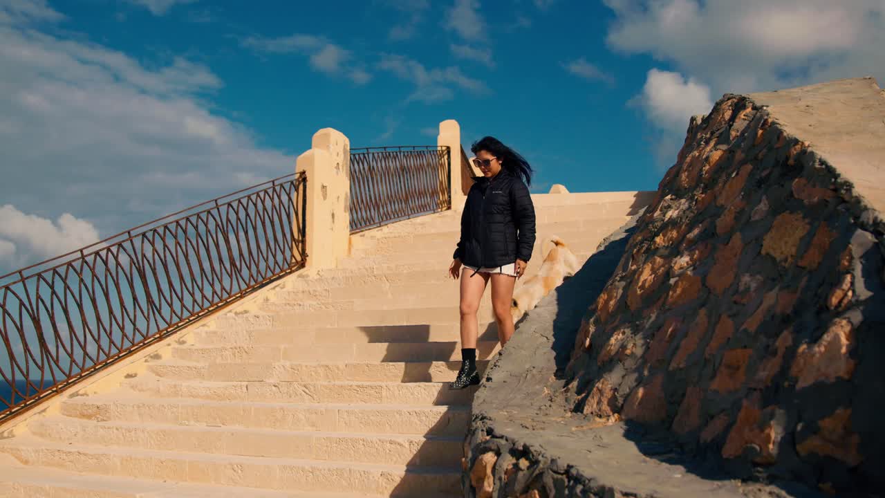 turista asiática caminando por las escaleras en la playa de cleopatra en marsa matrouh, egipto