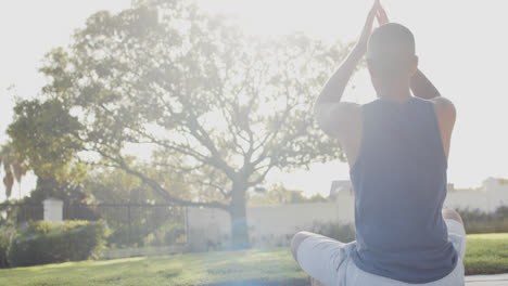 Fokussierter-Biracial-Mann,-Der-Yoga-Im-Sonnigen-Garten-Praktiziert,-Zeitlupe