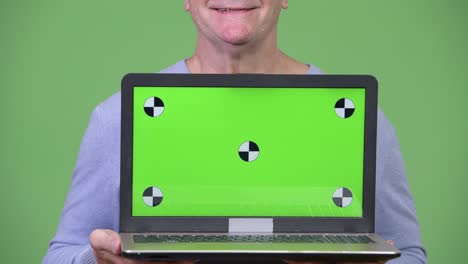 senior handsome man showing laptop