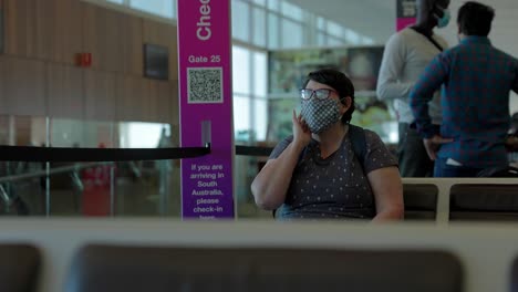 a lady sitting in the airport waiting lounge before she board her flight