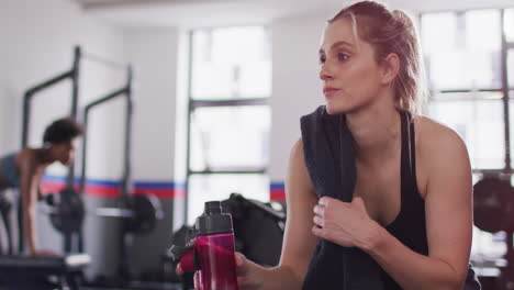 Vídeo-De-Una-Mujer-Caucásica-Bebiendo-Agua-Tomando-Un-Descanso-Del-Ejercicio-En-El-Gimnasio