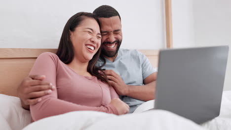 Bed,-laptop-and-couple-laughing