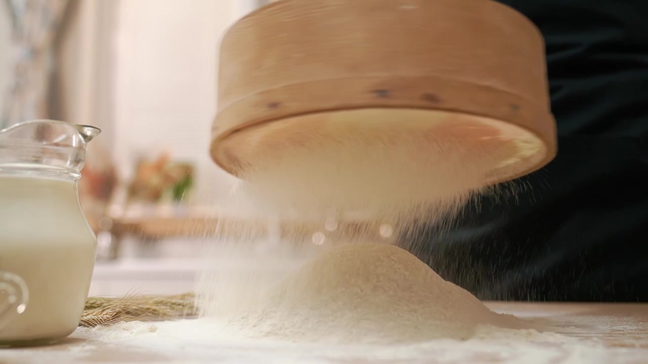 Primo piano: setacciatura di farina bianca con setaccio di legno