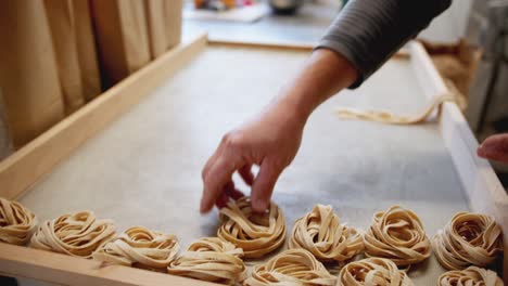 close up panning shot of an italian artisan making handmade pasta full of flour