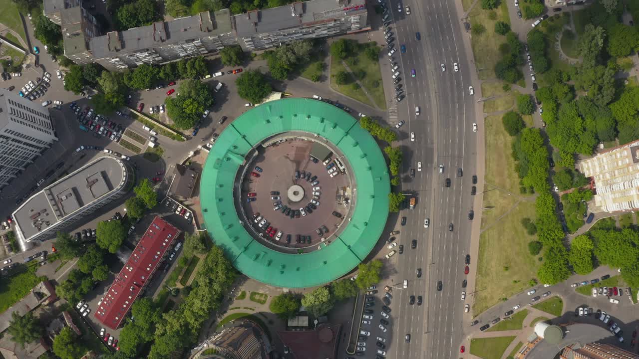 интересная круглая форма здания с зеленой крышей