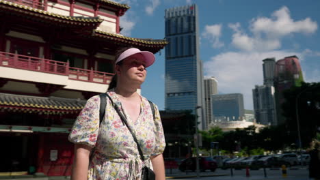 a woman walking in front of buddha tooth relic temple in chinatown district of singapore. parallax shot