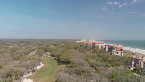 Vista-Aérea-Del-Bosque-De-La-Isla-Amelia-Con-Resorts-Y-El-Océano-Al-Fondo