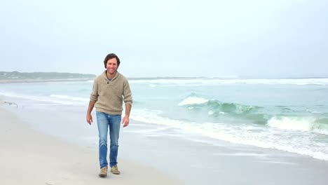 hombre feliz corriendo hacia la cámara en la playa