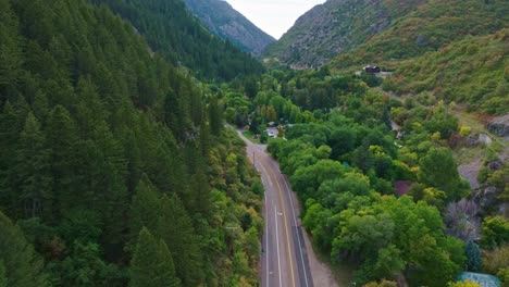 aerial over ogden utah canyon with beautiful pine forest and hotel next to the main road