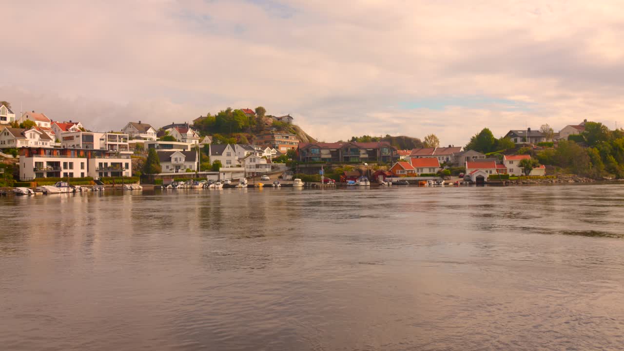 Scenic coastal homes by calm waters in Kristiansand, Norway at sunset