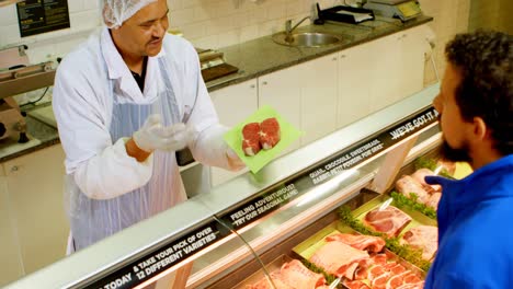 butcher selling meat to customer at shop 4k