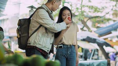 handheld view of vietnamese couple buying fruit at the market