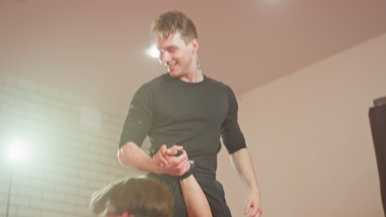 Wrestler flip and grapple opponent on red mat during intense ground fight training session as one athlete dominates top position while other struggles beneath, raw power, competitive spirit in gym environment