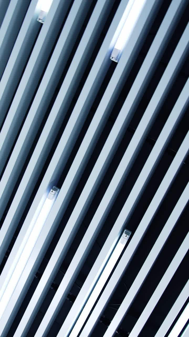 Decoration of the room with long planks. Lamps of white day light among the decorative panels. Low angle view. Vertical video