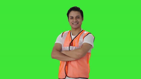 portrait of happy indian airport worker standing crossed hands green screen