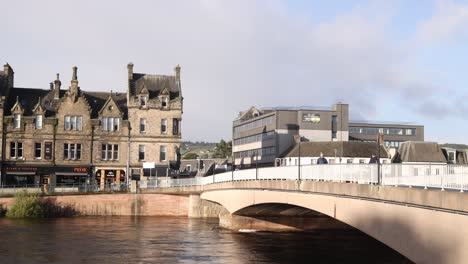 Toma-Panorámica-De-Escaparates,-Casas-Adosadas-Y-Puente-En-Inverness,-Escocia,-En-Las-Tierras-Altas