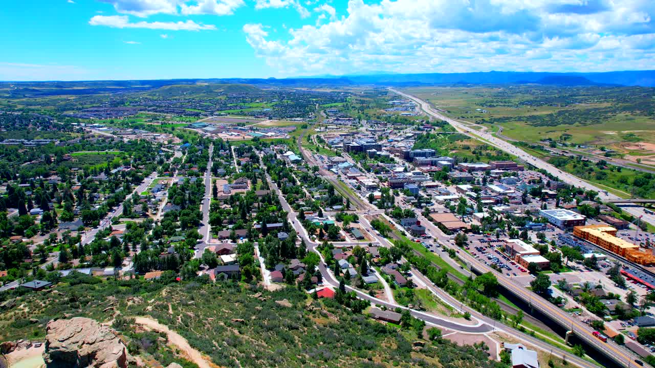 drone invirtiendo sobre el centro de castle rock colorado con montañas y denver en el fondo
