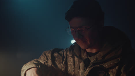 a bombmaker assembles a bomb in his workshop at night