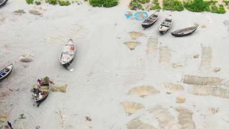 Coastal-livelihoods-seen-from-a-drone:-fishermen-and-traditional-boats-on-the-Kuakata-sea-beach,-Bangladesh