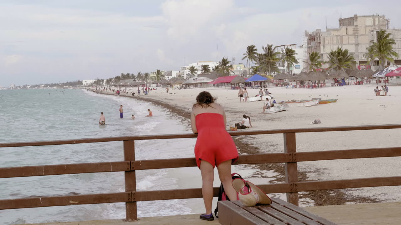 женщина в красном платье отчаливает от причала