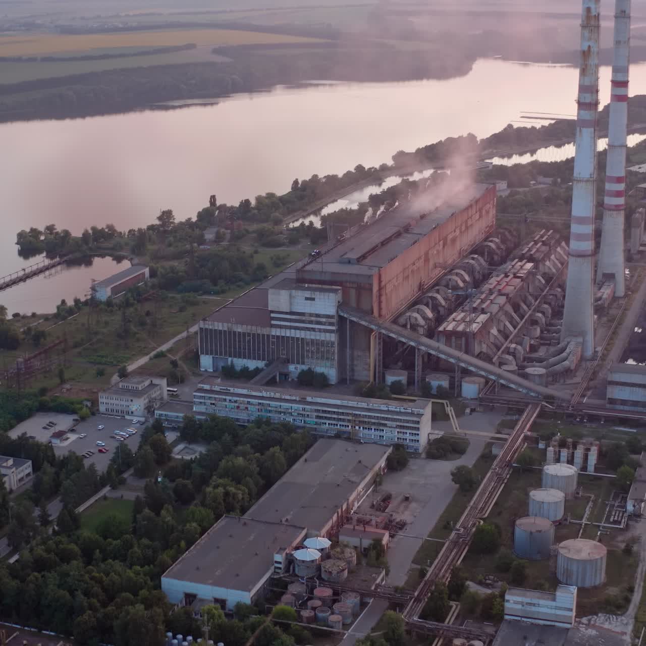 Site with high-voltage lines on the background of the road and trees at sunset. Camera motion forward. Aerial view