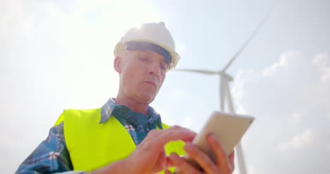 ingeniero que usa una tableta digital en una granja de turbinas eólicas 13