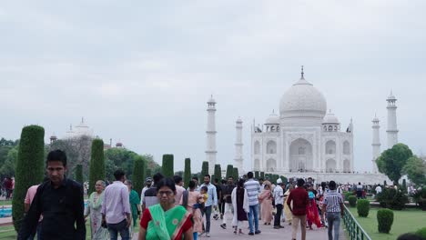 indian woman walking in front of taj mahal