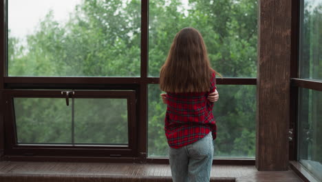 mujer mirando por la ventana