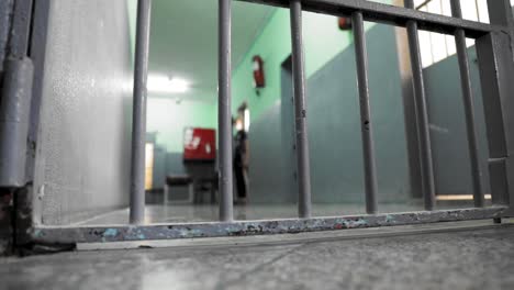 a prisoner standing in front of his cell inside a prison