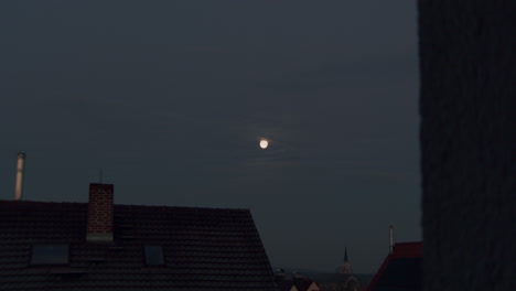 ultra wide shot to close up of the moon, slow zoom. stativ wide shot of the moon, camera facing west. a few cloud in front of the money.