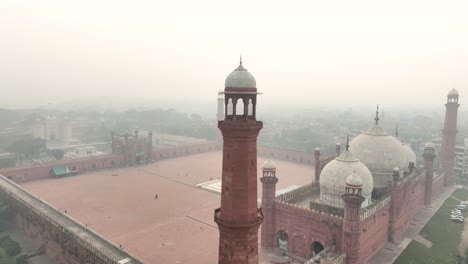 Mezquita-Badshahi-Envuelta-En-Niebla-Al-Amanecer,-Lahore,-Pakistán.-Aéreo