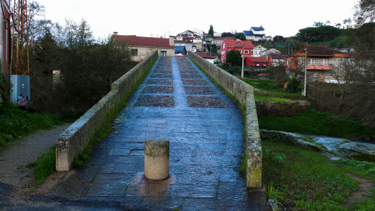 vista que conduce hasta el puente inclinado empinado con barrera de hormigón que detiene los coches, cruza el río ionia en ourense, españa