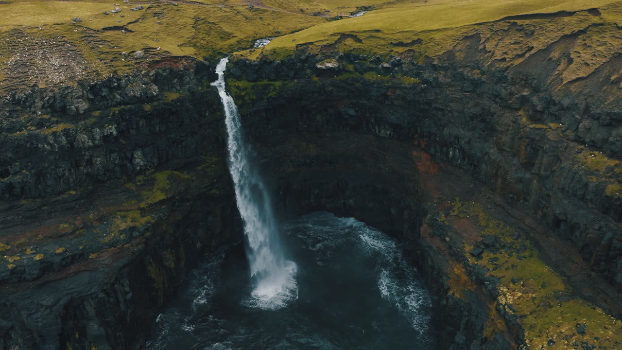 cascada de mulafossur, islas feroe: fantástica vista aérea en órbita y en la distancia media de la hermosa cascada y el viento golpeando el agua