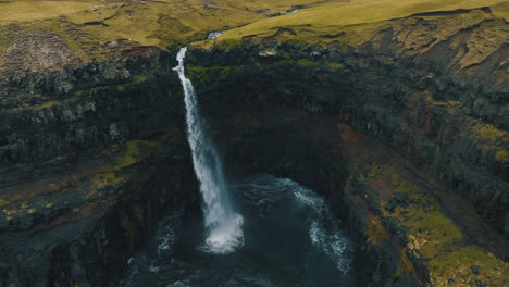 mulafossur waterfall, faroe islands: fantastic aerial view in orbit and in the middle distance of the beautiful waterfall and the wind hitting the water