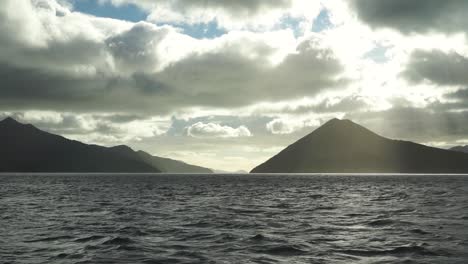 Morning-view-of-sun,-sky,-clouds,-hills-and-ocean-from-boat-in-Marlborough-Sounds,-New-Zealand