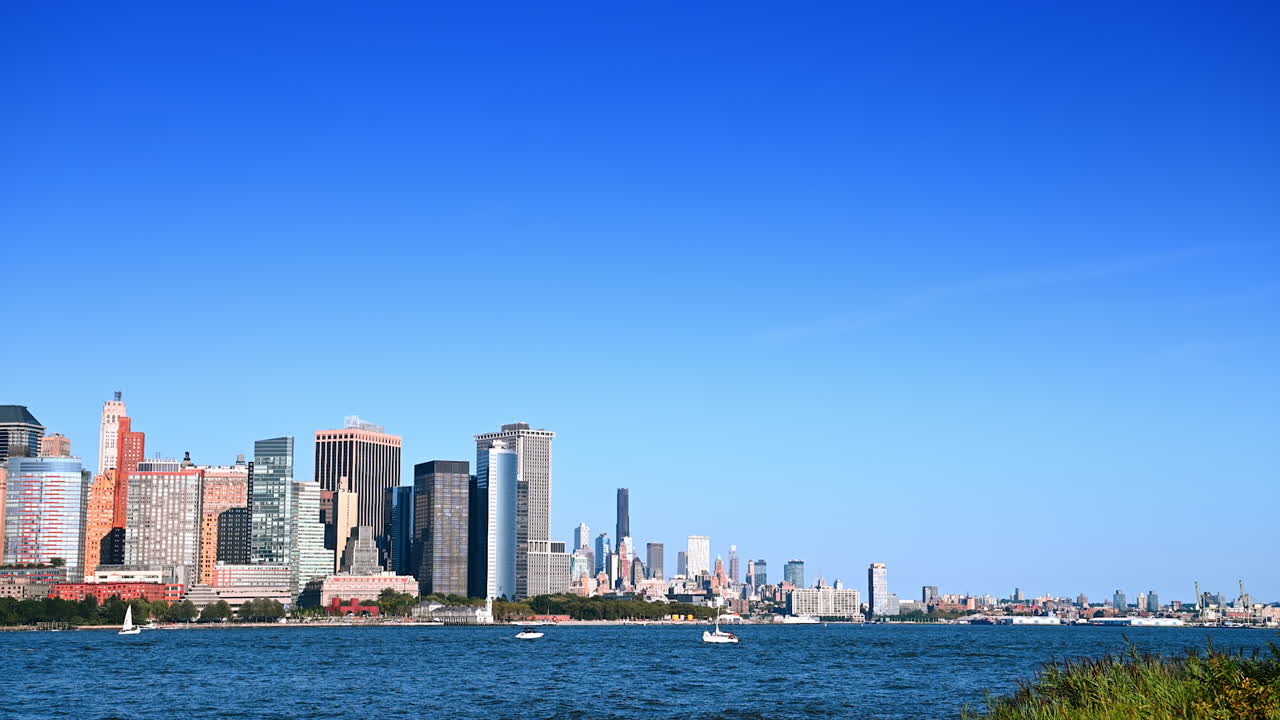 Modern urban skyline of beautiful Manhattan on clear sunny day. View across the blue waterscape of the Hudson River from Jersey