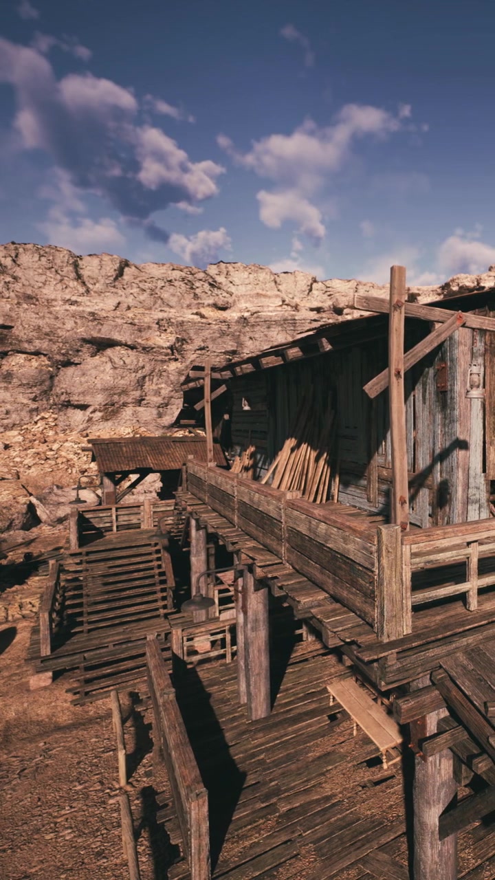 Gammel trækonstruktion nær klippefyldt terræn på en klar solskinsdag
