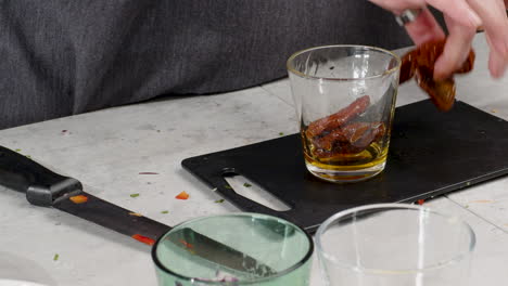 slow motion shot of a chef taking dates out of a glass and the cutting them up on a chopping board