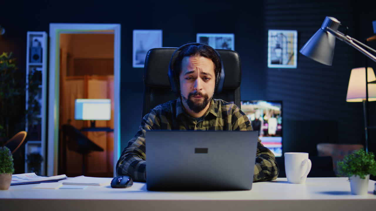 Man listening music in living room office while answering emails