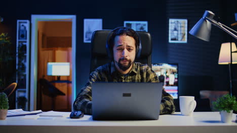 man listening music in living room office while answering emails