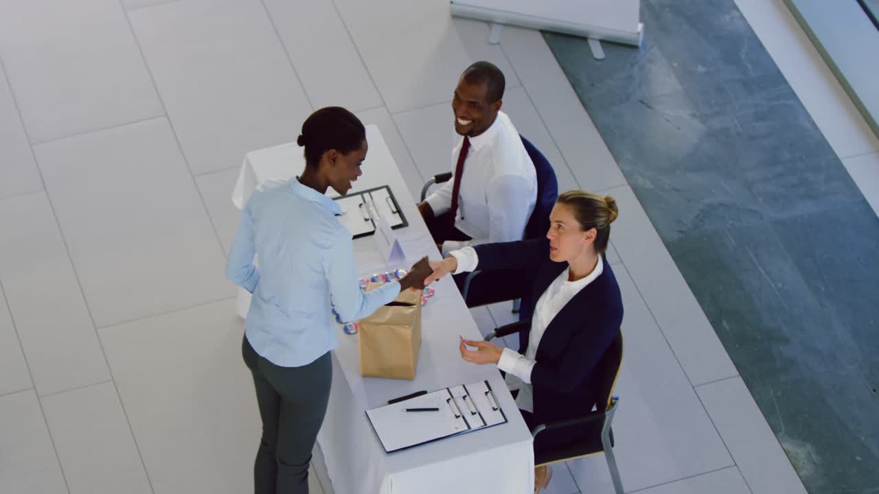 donna d'affari che si registra al tavolo di registrazione della conferenza 4k