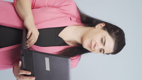 video vertical de una mujer de negocios mirando una computadora portátil con emoción.