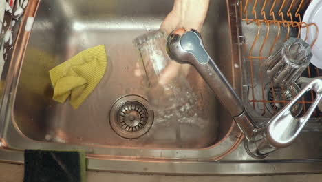 footage of man's hands washing dishes