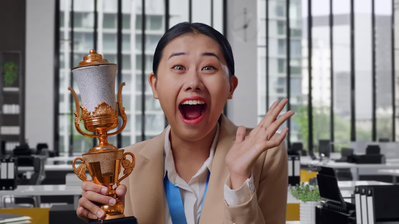 Woman Celebrating Achievement With Trophy in Office