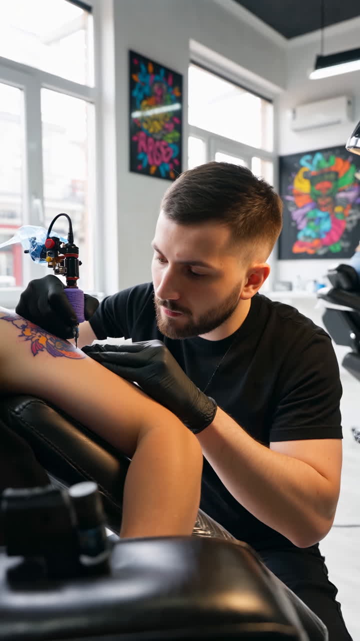 A professional tattoo artist applying a tattoo on a client's arm in a modern studio