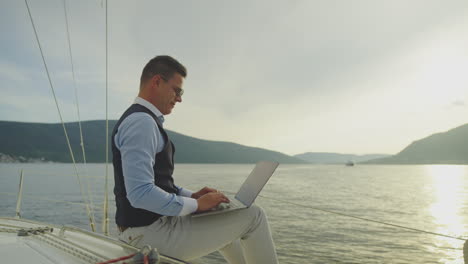 businessman working on a laptop on a yacht