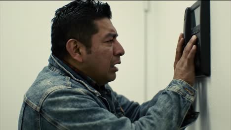 a man experiences a moment of intense emotion as he interacts with a communication device, reflecting feelings of anxiety and anticipation inside a simplistic room environment.